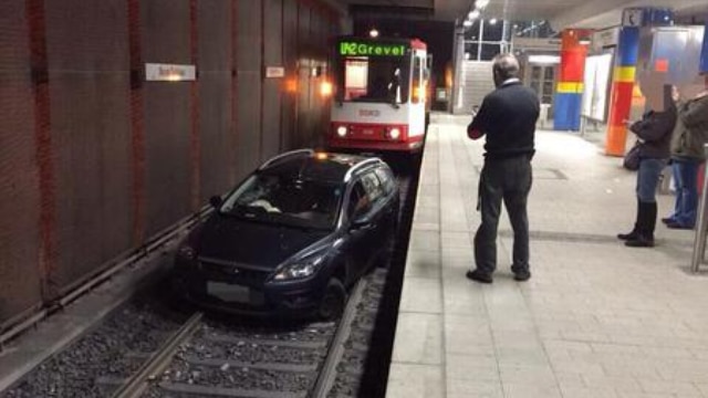 Ivre, il suit un tramway avec sa voiture et s'arrête sur les voies dans une station