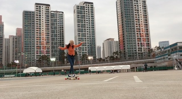 Elle danse sur un longboard